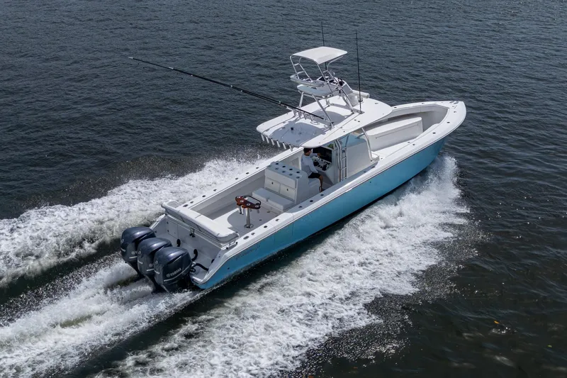 Slide: The Image of 2015 Bahama 41 boat cruising on water with triple outboard engines. - 26
