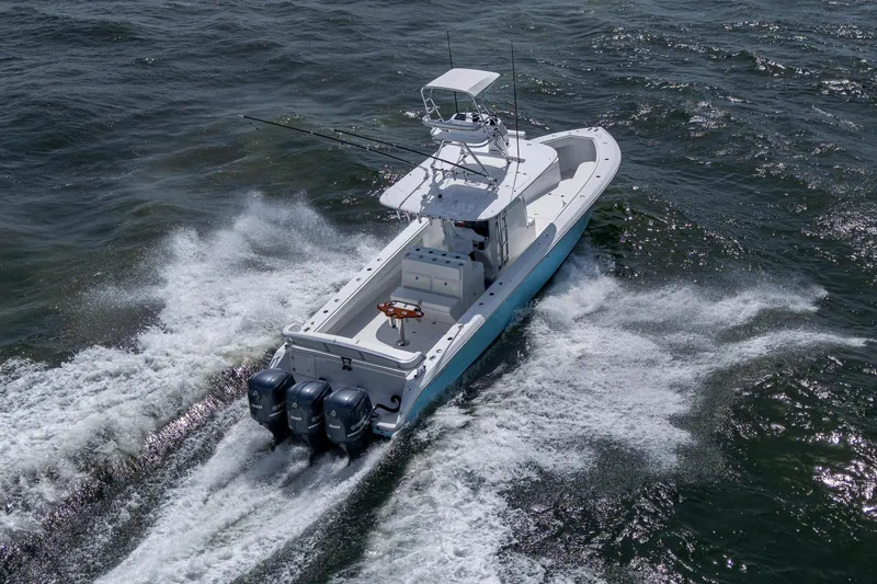 Slide: The Image of 2015 Bahama 41 boat cruising on open water with triple outboard engines. - 30