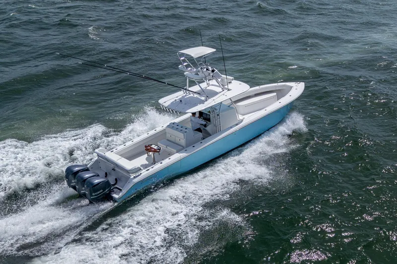Slide: The Image of 2015 Bahama 41 boat cruising on open water, featuring triple outboard engines. - 31