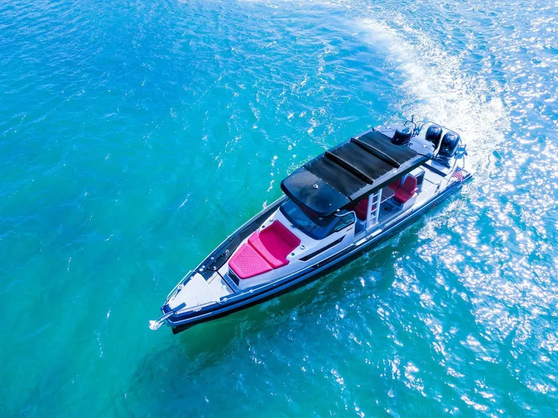 Slide: The Image of 2018 Axopar 37 Sun Top boat cruising on clear blue water. - 10