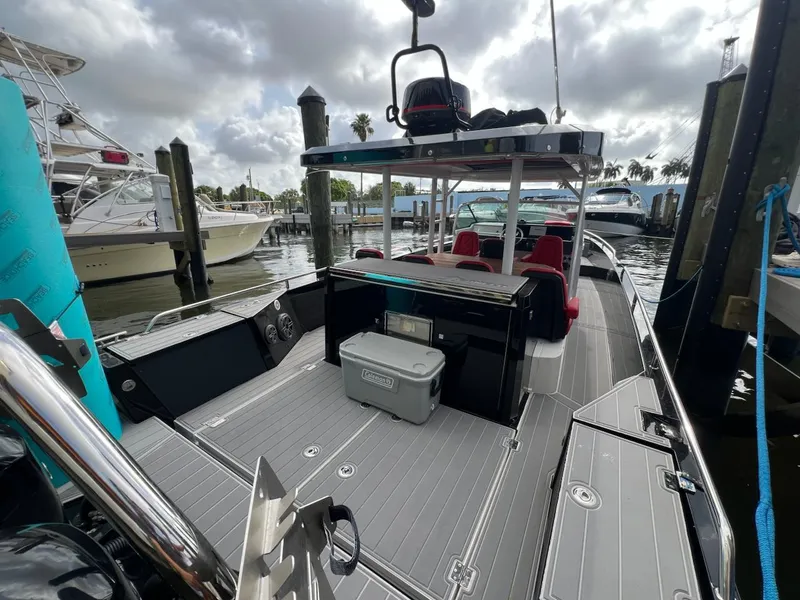 Slide: The Image of 2018 Axopar 37 Sun Top boat docked, featuring spacious deck and seating area. - 11