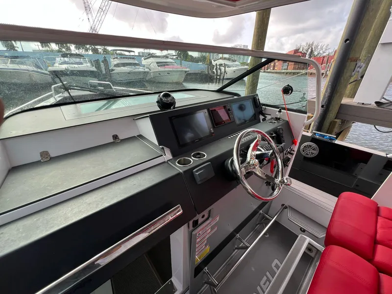 Slide: The Image of 2018 Axopar 37 Sun Top boat helm with modern controls and red seating. - 19
