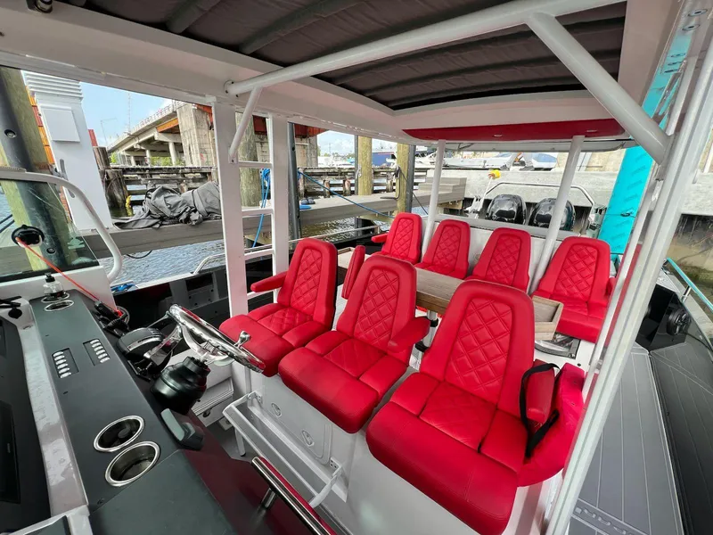 Slide: The Image of 2018 Axopar 37 Sun Top boat interior with red seats and modern dashboard. - 20