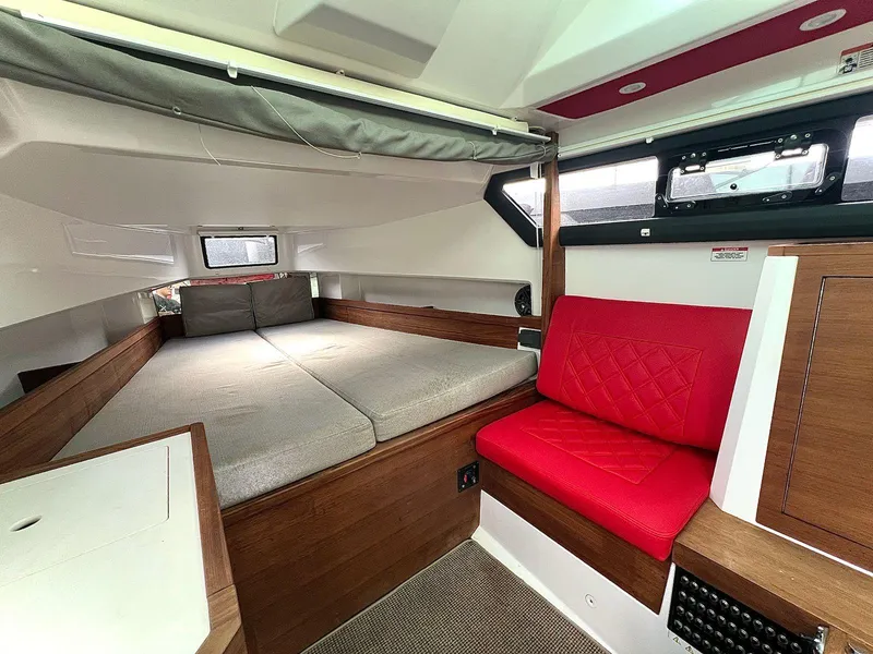 Slide: The Image of Interior of 2018 Axopar 37 Sun Top with cozy bed and red seating. - 22