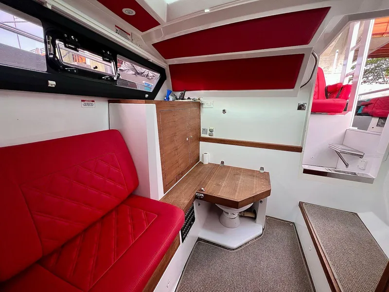 Slide: The Image of Interior of 2018 Axopar 37 Sun Top with red seating and wooden accents. - 23