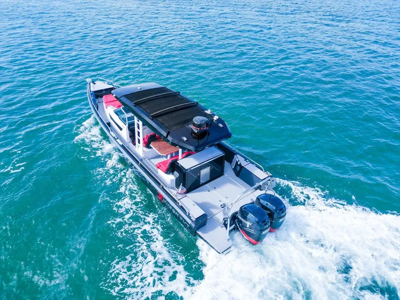 Slide: The Image of 2018 Axopar 37 Sun Top cruising on clear blue water. - 5