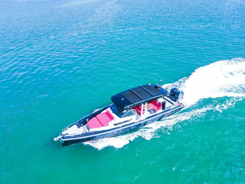 Slide: The Image of 2018 Axopar 37 Sun Top cruising on clear blue water. - 7