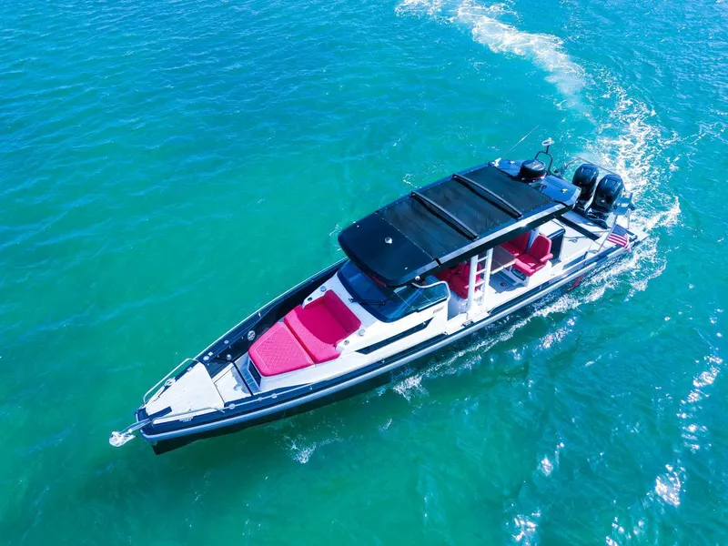Slide: The Image of 2018 Axopar 37 Sun Top boat cruising on clear blue water. - 9