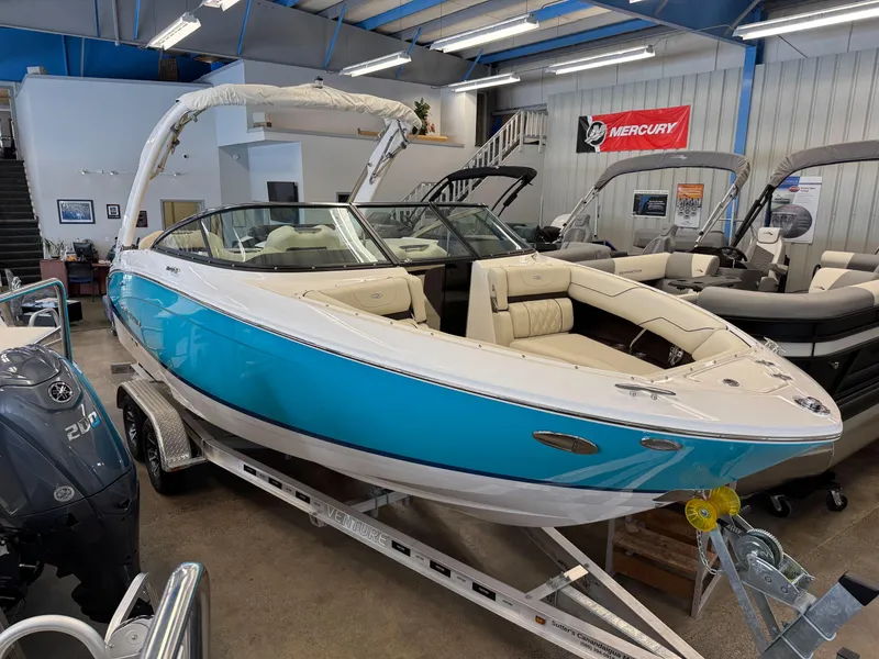 The Image of 2025 Regal LS4 boat in showroom, blue and white design, on trailer, indoor display. - 1