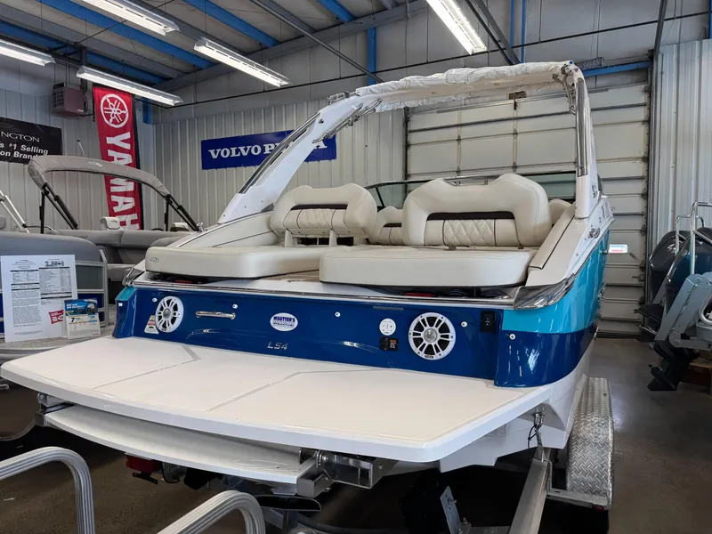 Slide: The Image of 2025 Regal LS4 boat in showroom, featuring white and blue design with comfortable seating. - 2