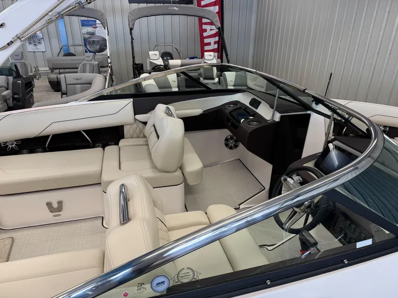 Slide: The Image of 2025 Regal LS4 boat interior with luxurious seating and modern dashboard in a showroom. - 4