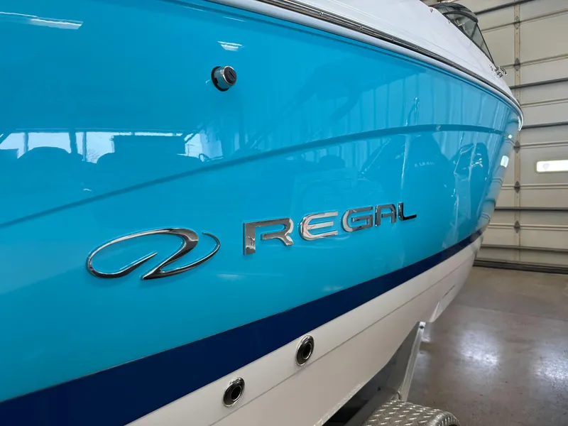Slide: The Image of 2025 Regal LS4 boat with blue and white exterior in a garage setting. - 7