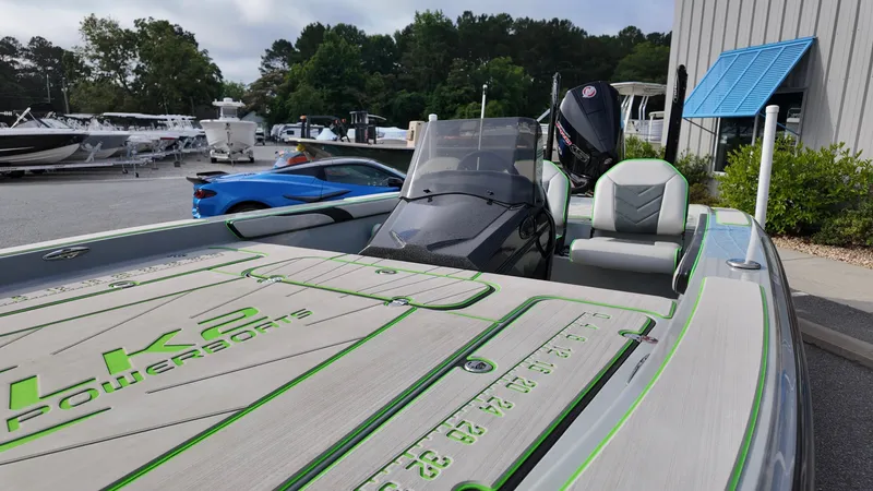 Slide: The Image of 2025 ALK2 Powerboats 21 BHX, sleek design, parked outdoors near other boats. - 8