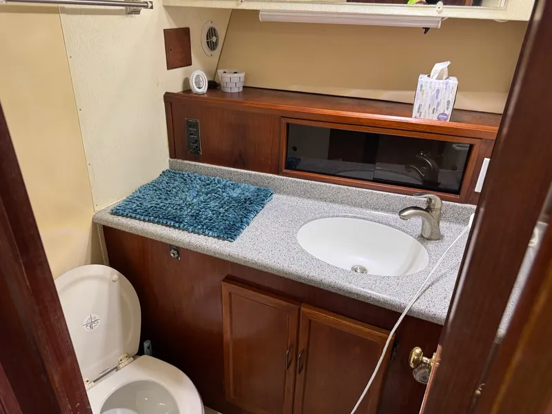Slide: The Image of 1982 Viking 46 Convertible yacht bathroom with sink, toilet, and wooden cabinetry. - 15