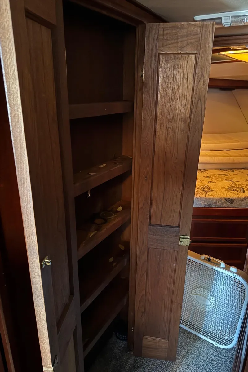 Slide: The Image of Wooden closet and bed inside a 1982 Viking 46 Convertible boat cabin. - 17