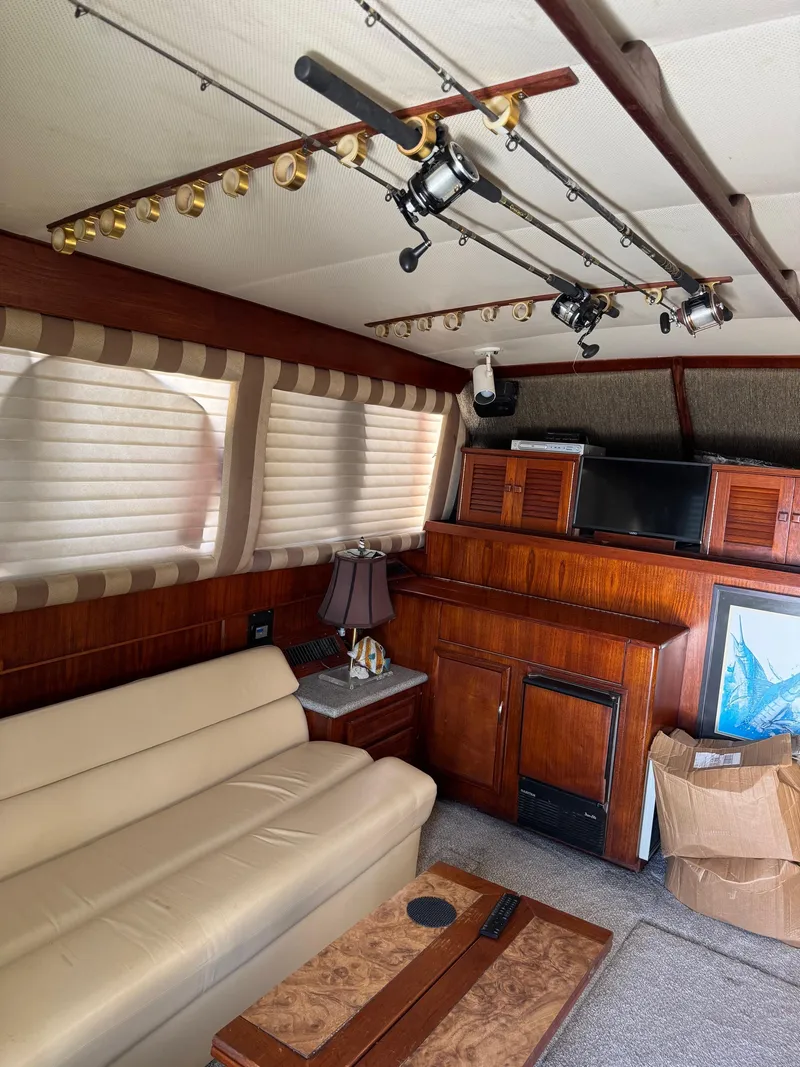 Slide: The Image of Interior of 1982 Viking 46 Convertible yacht with fishing rods, sofa, and wooden cabinetry. - 9