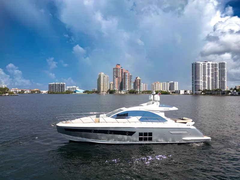 Slide: The Image of 2016 Azimut 55S yacht cruising on a sunny day with city skyline backdrop. - 12