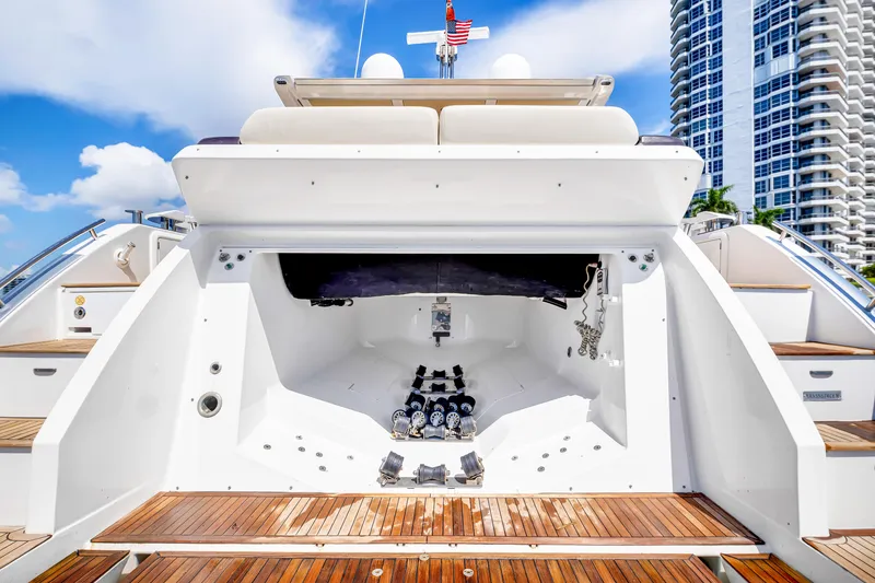 Slide: The Image of 2016 Azimut 55S yacht stern view with wooden deck and urban skyline backdrop. - 20