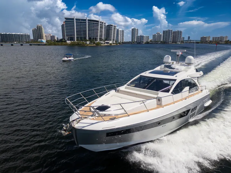 Slide: The Image of 2016 Azimut 55S yacht cruising in a scenic urban waterway with modern buildings. - 4