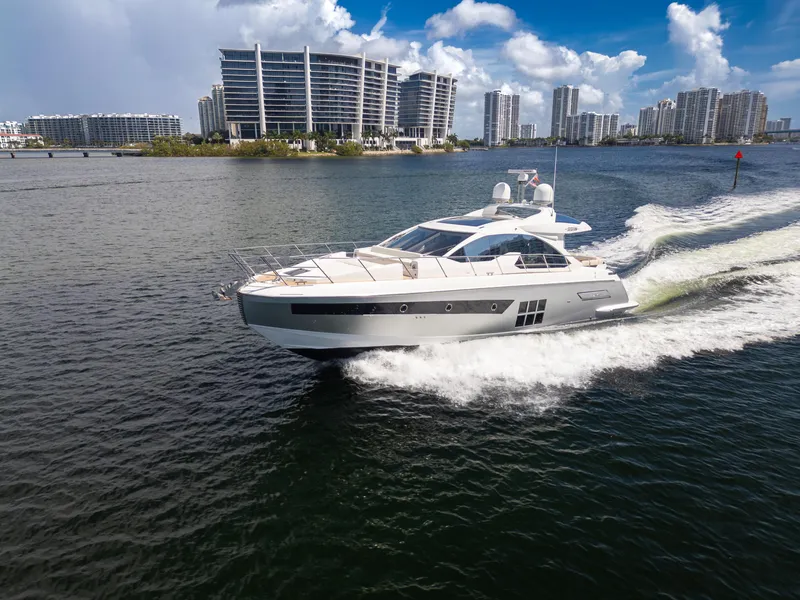 Slide: The Image of 2016 Azimut 55S yacht cruising on water with cityscape background. - 5