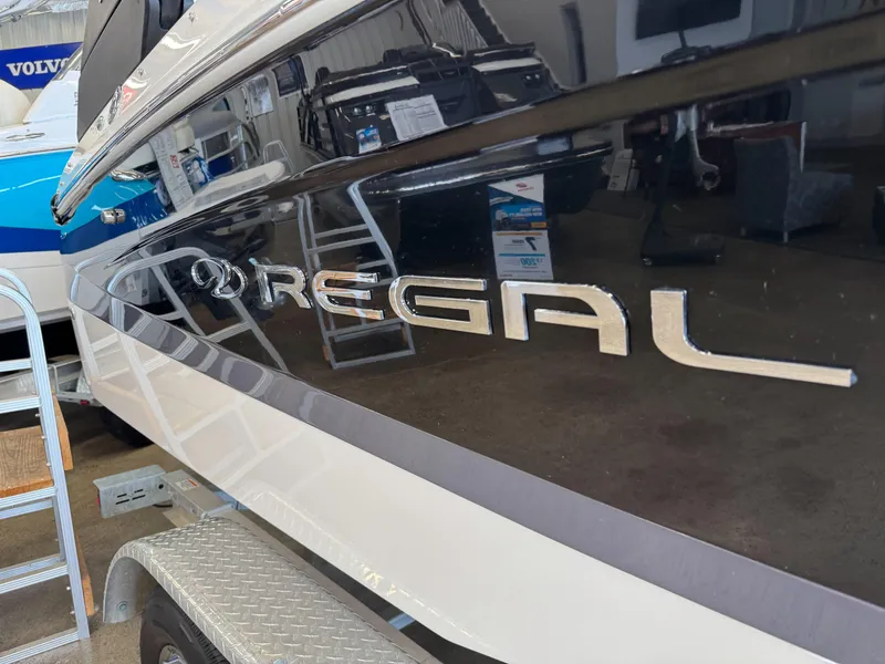 Slide: The Image of 2025 Regal LS2 boat side view with logo, displayed indoors. - 20