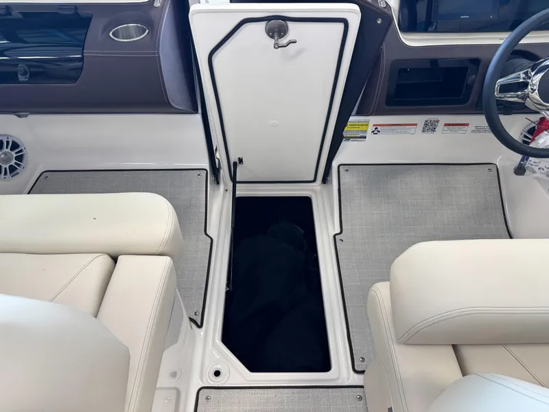 Slide: The Image of Interior of 2025 Regal LS2 boat with open storage compartment and beige seating. - 4