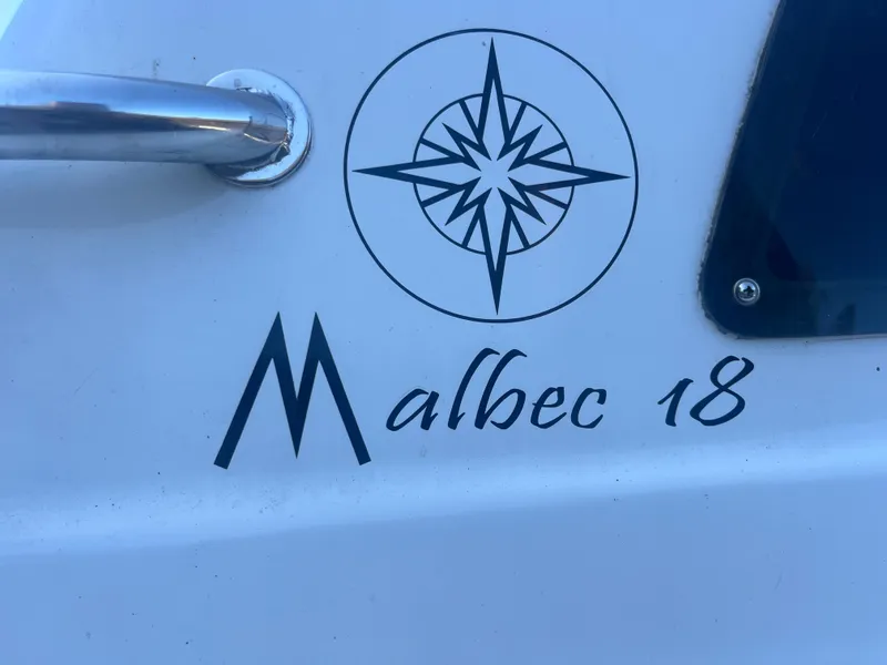 Slide: The Image of Malbec 18 boat logo with compass design, 2023 model. - 13