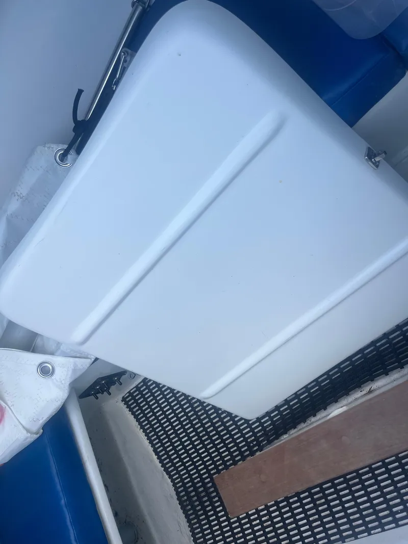 Slide: The Image of White compartment on Malbec 18 boat, 2023 model, with blue seating and netted flooring. - 5