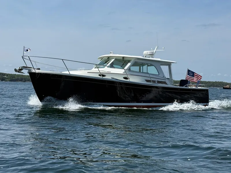 The Image of 2019 Back Cove Downeast boat cruising on water with American flag. - 0
