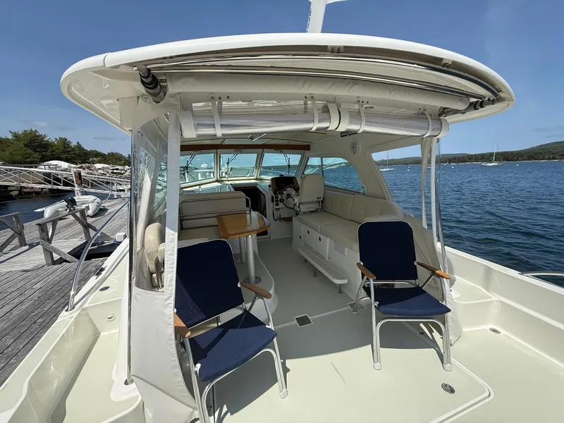 Slide: The Image of 2019 Back Cove Downeast boat interior with seating, docked by the water. - 16