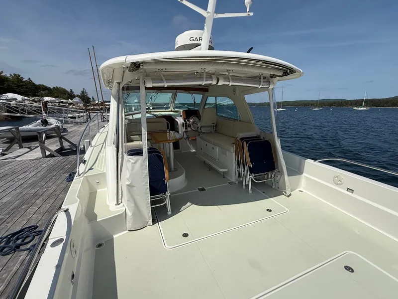 Slide: The Image of 2019 Back Cove Downeast boat docked, featuring spacious deck and seating area. - 18