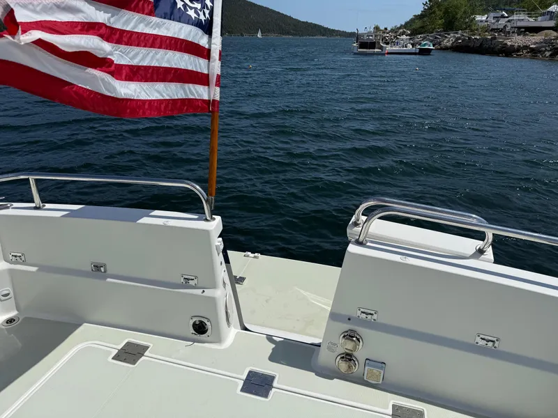 Slide: The Image of 2019 Back Cove Downeast boat with American flag on a scenic waterway. - 20