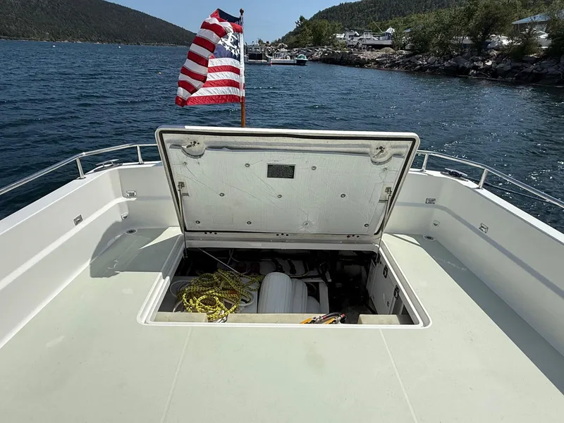 Slide: The Image of 2019 Back Cove Downeast boat with open hatch, American flag, and scenic water view. - 21
