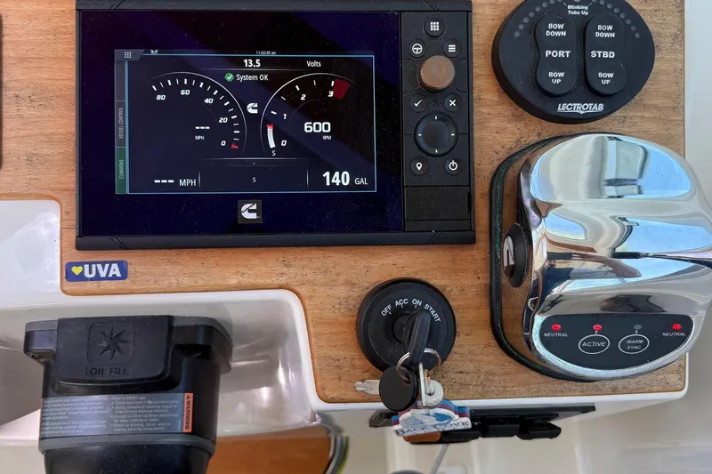 Slide: The Image of 2019 Back Cove Downeast boat dashboard with control panel and gauges. - 32