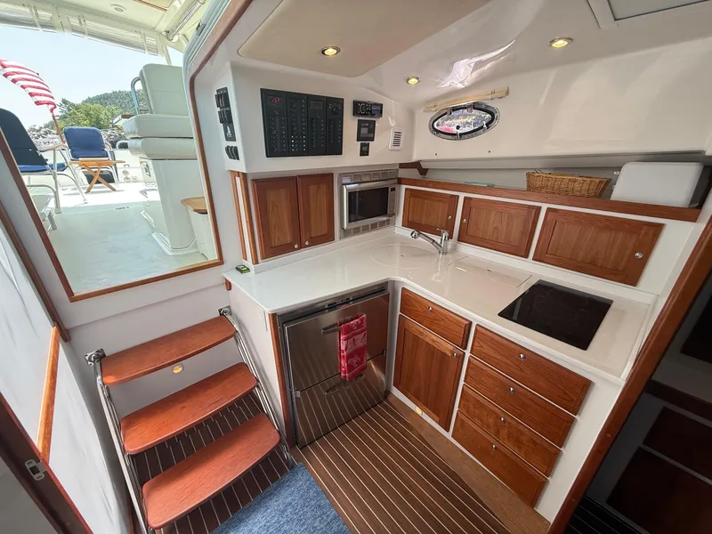 Slide: The Image of 2019 Back Cove Downeast yacht interior with modern kitchen and wooden cabinetry. - 34