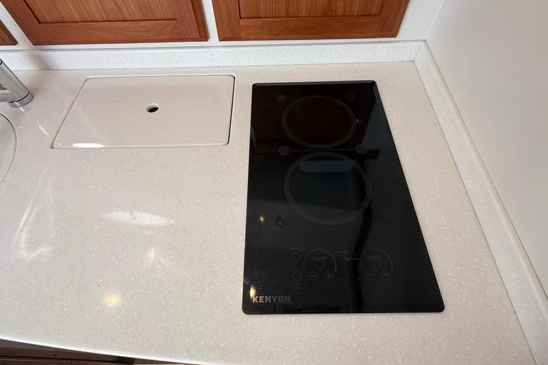 Slide: The Image of 2019 Back Cove Downeast kitchen with Kenyon cooktop and sleek countertop design. - 39