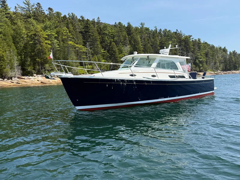 Slide: The Image of 2019 Back Cove Downeast boat on scenic water with forested shoreline. - 4
