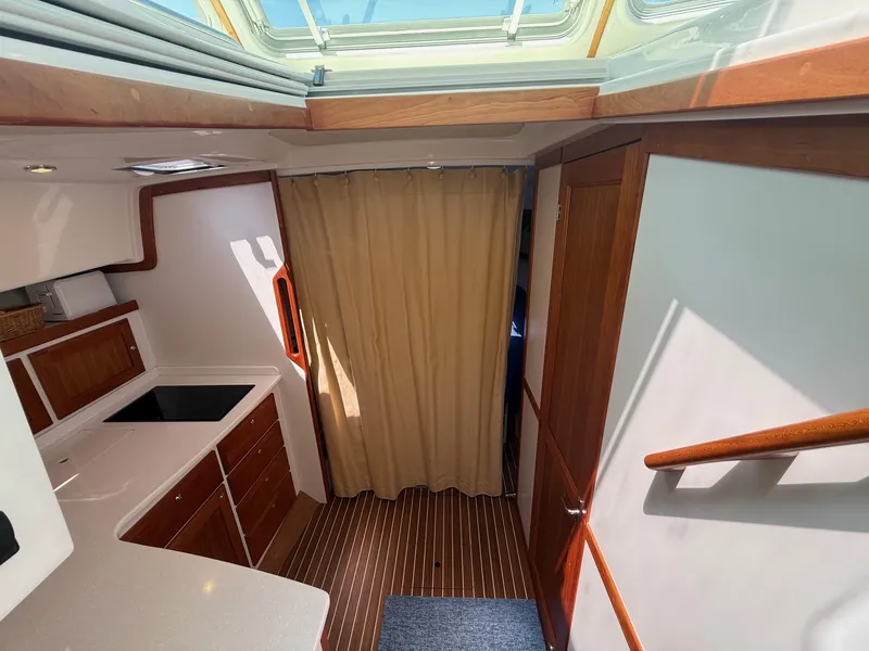 Slide: The Image of 2019 Back Cove Downeast interior with wood cabinetry, skylight, and striped flooring. - 43