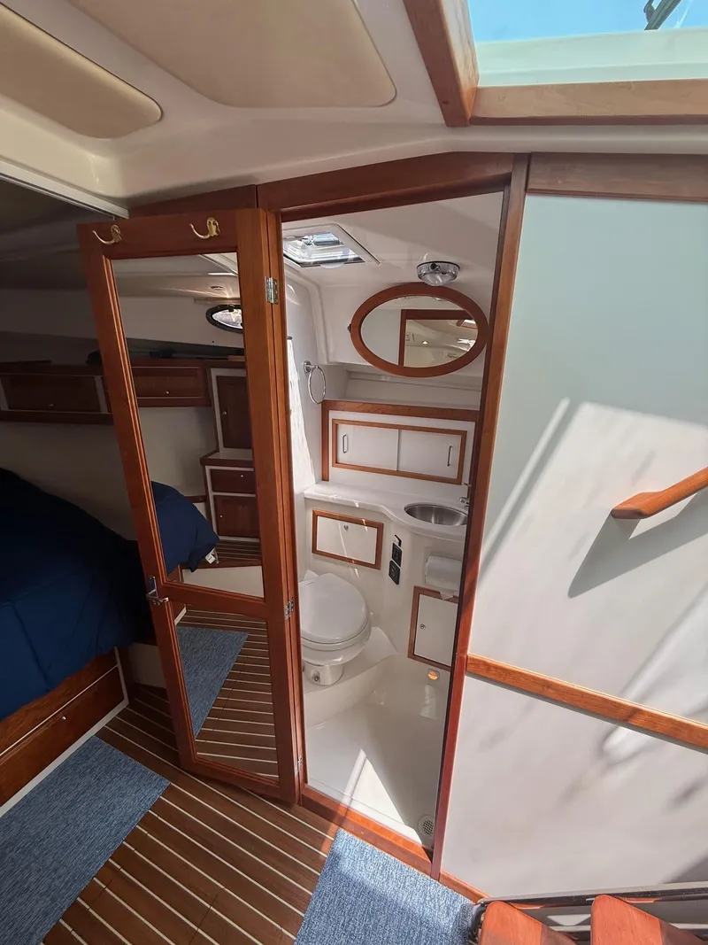 Slide: The Image of 2019 Back Cove Downeast yacht interior with wooden finishes, featuring a compact bathroom and cozy cabin. - 45