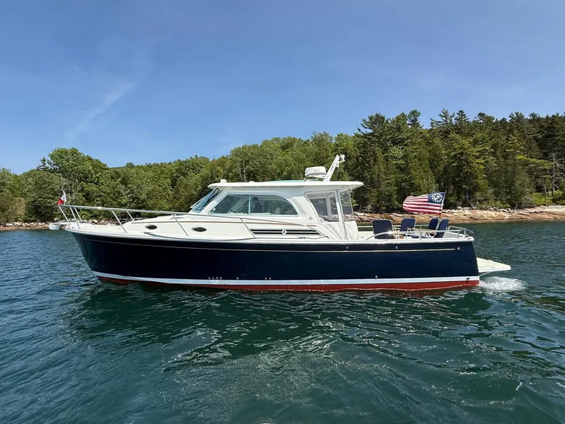 Slide: The Image of 2019 Back Cove Downeast boat cruising on a scenic lake with forested shoreline. - 6