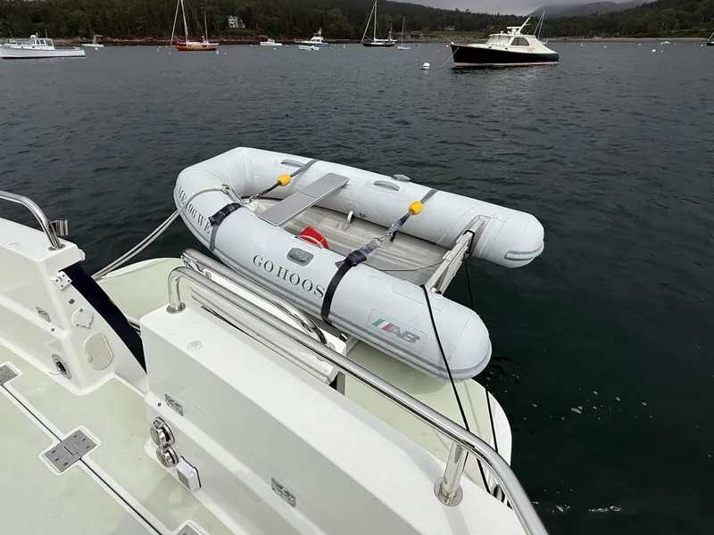 Slide: The Image of 2019 Back Cove Downeast boat with inflatable dinghy on calm water. - 9