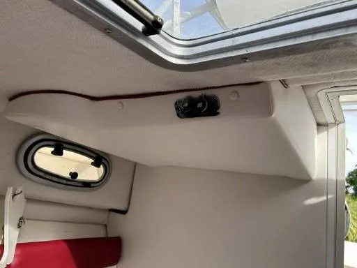 Slide: The Image of Interior cabin view of a 1998 Boston Whaler 23 Conquest boat, showing a window and ceiling details. - 12
