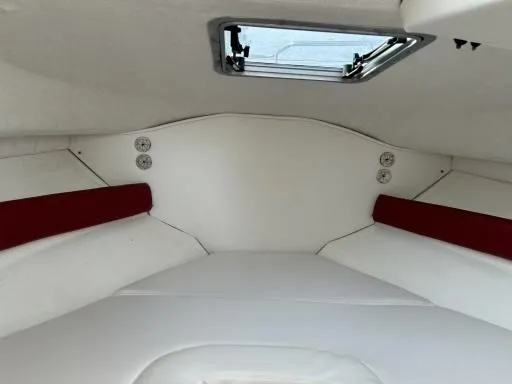 Slide: The Image of Interior cabin of a 1998 Boston Whaler 23 Conquest boat, featuring white and red upholstery. - 13