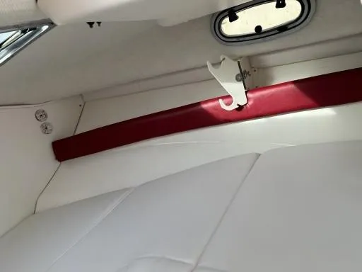 Slide: The Image of Interior cabin of a 1998 Boston Whaler 23 Conquest boat, featuring white and red accents. - 14