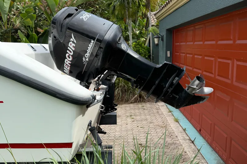 Slide: The Image of 1998 Boston Whaler 23 Conquest with Mercury OptiMax outboard motor near red garage door. - 16