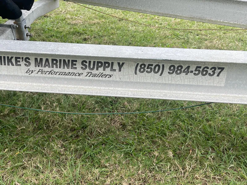 Slide: The Image of Trailer with "Mike's Marine Supply" contact, grass background. Boston Whaler 23 Conquest, 1998. - 19