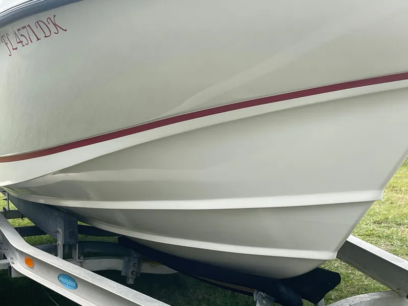 Slide: The Image of 1998 Boston Whaler 23 Conquest boat on trailer, side view with red stripe. - 4