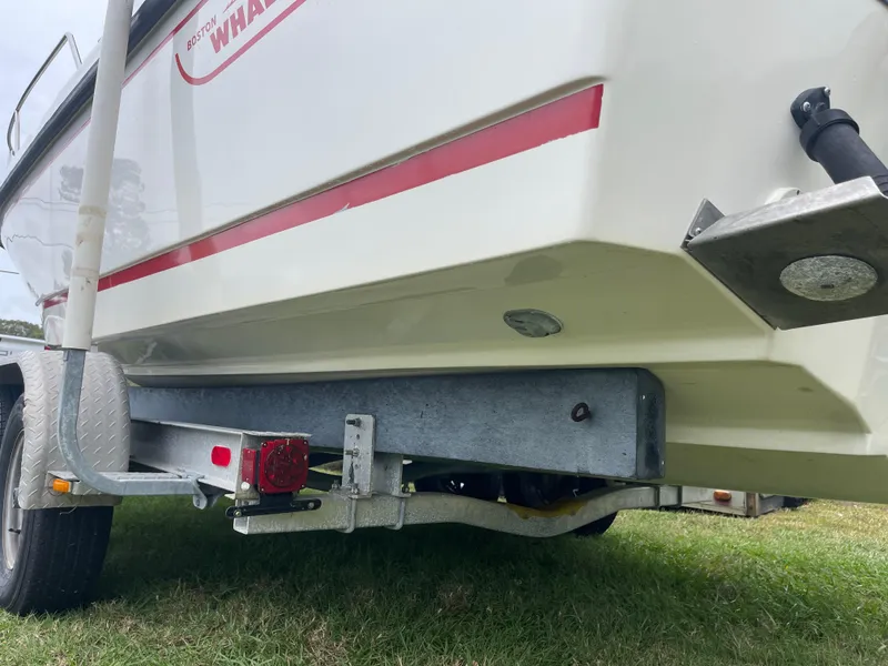 Slide: The Image of 1998 Boston Whaler 23 Conquest boat on trailer, side view, grassy background. - 6