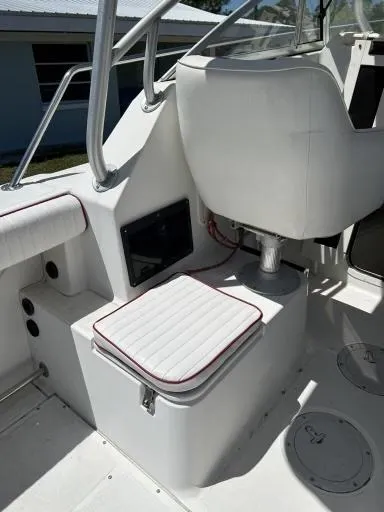 Slide: The Image of 1998 Boston Whaler 23 Conquest boat interior with white seating and storage compartments. - 9