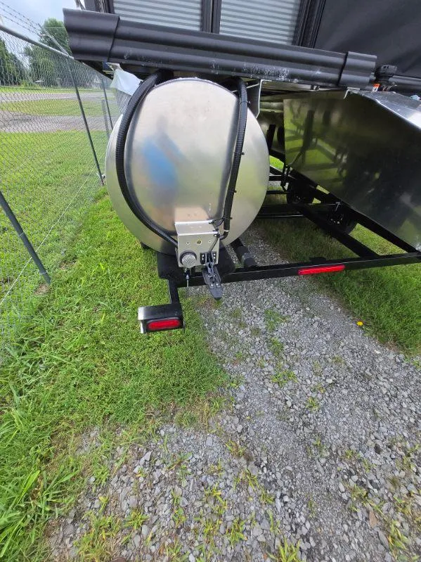 Slide: The Image of 2025 Qwest 20 XRE FISH boat trailer on gravel near a fence. - 14